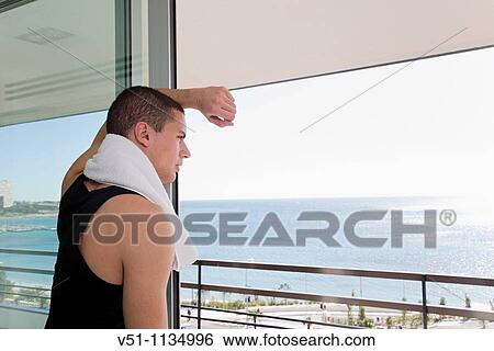 Young man enjoyning the views and looking at the sea and horizon View Large Photo Image Stock Photograph - Young man enjoyning the views and looking at the sea and horizon. Fotosearch