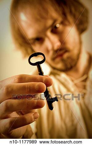 Young man holding a key View Large Photo Image Stock Photo - Young man holding a key. Fotosearch