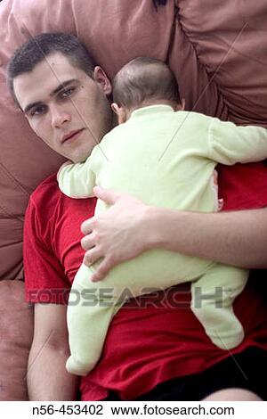 Stock Image - Young man holding baby. Fotosearch
