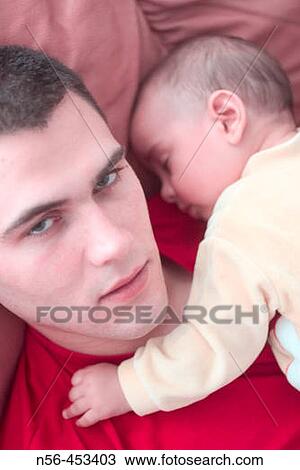 Young man holding baby View Large Photo Image Stock Image - Young man holding baby. Fotosearch