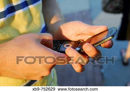 Young man holding cell phone View Large Photo Image Stock Photo - Young man holding cell phone. Fotosearch