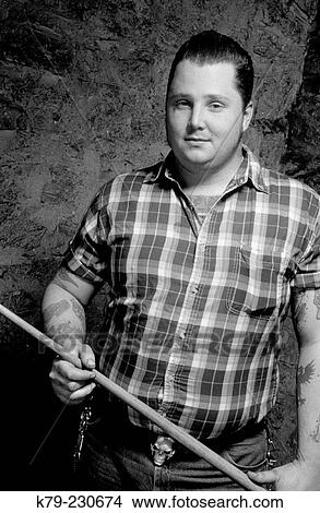 Young man holding cue stick. View Large Photo Image Picture - Young man holding cue stick.. Fotosearch