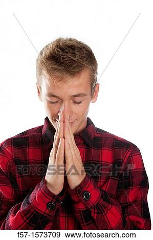 Young man holding his hand in a praying position View Large Photo Image Stock Photo - Young man holding his hand in a praying position. Fotosearch