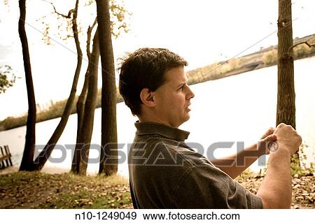 Young man in front of a river View Large Photo Image Stock Photo - Young man in front of a river. Fotosearch