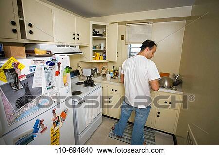 Young man in his kitchen View Large Photo Image Stock Image - Young man in his kitchen. Fotosearch