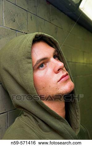 Young man in hooded sweat top seems bored and disaffected. View Large Photo Image Stock Photograph - Young man in hooded sweat top seems bored and disaffected.. Fotosearch