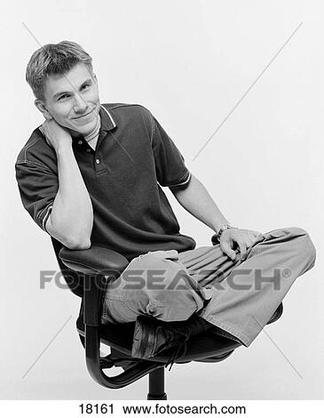Young man in office chair View Large Photo Image Stock Image - Young man in office chair. Fotosearch