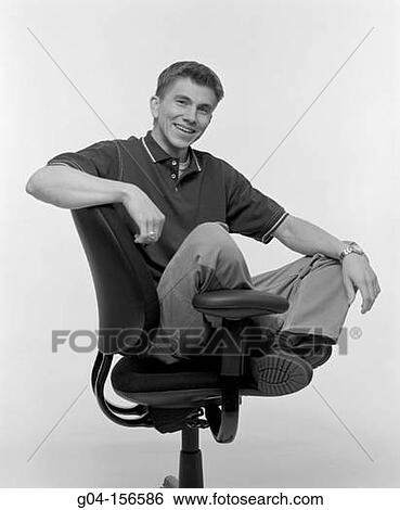 Young man in office chair View Large Photo Image Stock Photograph - Young man in office chair. Fotosearch