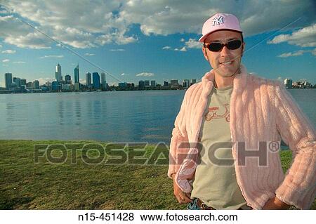 Young man in pink with city skyline in background View Large Photo Image Stock Photo - Young man in pink with city skyline in background. Fotosearch