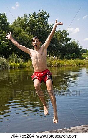 Young man jumping backward into a lake View Large Photo Image Picture - Young man jumping backward into a lake. Fotosearch