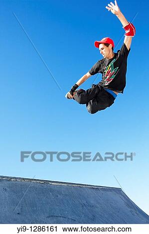 Young man jumping in mid air wearing inline skates View Large Photo Image Stock Image - Young man jumping in mid air wearing inline skates. Fotosearch
