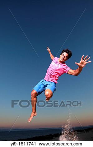 Young man jumping View Large Photo Image Stock Image - Young man jumping. Fotosearch