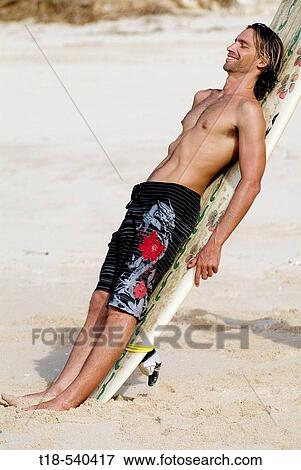young man leaning to surfboard View Large Photo Image Stock Photo - young man leaning to surfboard. Fotosearch