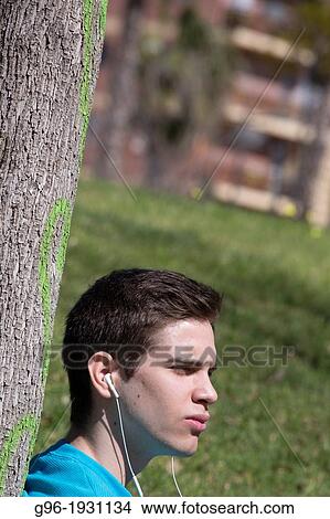 Young man listening music with earphones View Large Photo Image Picture - Young man listening music with earphones. Fotosearch