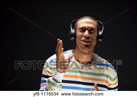 Picture - Young man listening to music.. Fotosearch