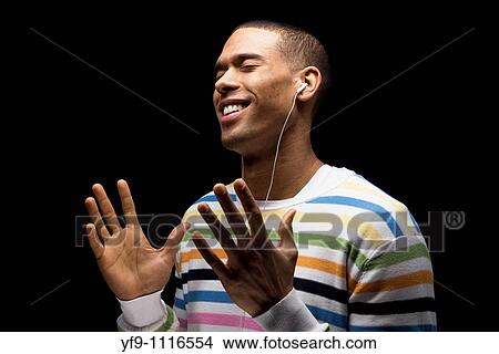 Young man listening to music. View Large Photo Image Picture - Young man listening to music.. Fotosearch