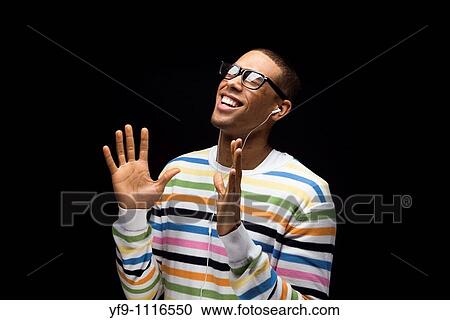 Stock Image - Young man listening to music.. Fotosearch