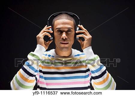 Young man listening to music. View Large Photo Image Stock Photo - Young man listening to music.. Fotosearch