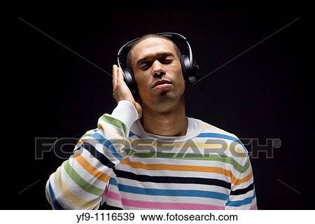Young man listening to music. View Large Photo Image Stock Photo - Young man listening to music.. Fotosearch