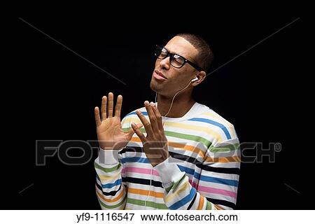 Stock Photo - Young man listening to music.. Fotosearch