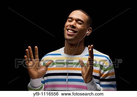 Young man listening to music. View Large Photo Image Stock Photograph - Young man listening to music.. Fotosearch
