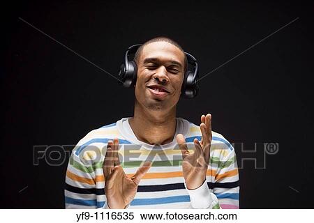 Young man listening to music. View Large Photo Image Stock Photography - Young man listening to music.. Fotosearch