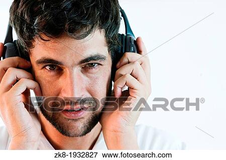 Stock Photo - Young man listening to music with headphones. Fotosearch
