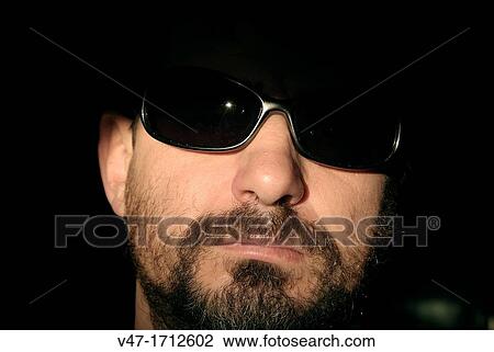 young man looking at camera behind sunglasses, emerging from the shadow View Large Photo Image Stock Image - young man looking at camera behind sunglasses, emerging from the shadow. Fotosearch
