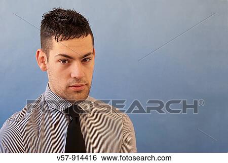 Young man looking at the camera View Large Photo Image Stock Photograph - Young man looking at the camera. Fotosearch