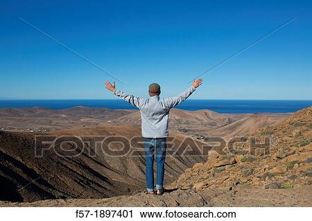 Young man looking at the view in Fuerteventura, Spain View Large Photo Image Stock Image - Young man looking at the view in Fuerteventura, Spain. Fotosearch