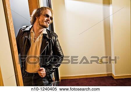 Young man looking out an office door View Large Photo Image Stock Photography - Young man looking out an office door. Fotosearch