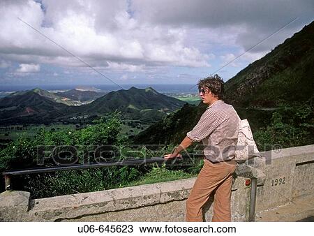 Young man looking over East Oahu from the pali Lookout in Hawaii, USA View Large Photo Image Stock Image - Young man looking over East Oahu from the pali Lookout in Hawaii, USA. Fotosearch