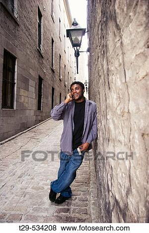 Young man on a cell phone. View Large Photo Image Stock Photo - Young man on a cell phone.. Fotosearch