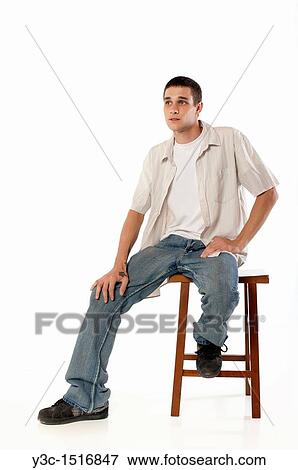 Young man on a chair View Large Photo Image Stock Photo - Young man on a chair. Fotosearch