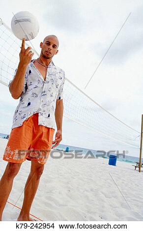 Young man on beach with volley ball. View Large Photo Image Picture - Young man on beach with volley ball.. Fotosearch