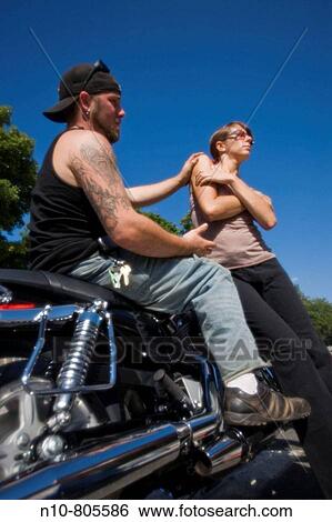 Young man, on his motorcycle, with a young woman. View Large Photo Image Stock Photograph - Young man, on his motorcycle, with a young woman.. Fotosearch