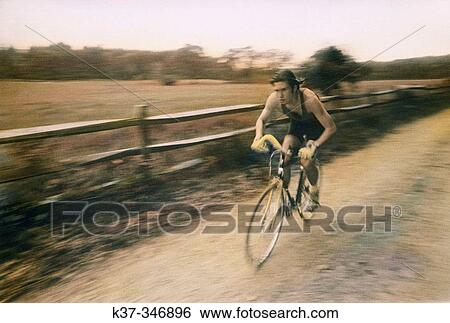 Young man on racing bike on dirt road. Hand colored & sepia-toned. View Large Photo Image Stock Photograph - Young man on racing bike on dirt road. Hand colored & sepia-toned.. Fotosearch