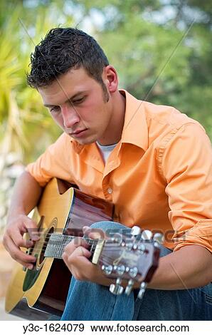Young man playing guitar View Large Photo Image Stock Photo - Young man playing guitar. Fotosearch