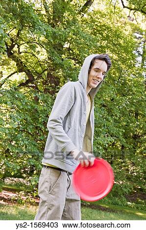 Young man playing with a frisbee View Large Photo Image Stock Image - Young man playing with a frisbee. Fotosearch
