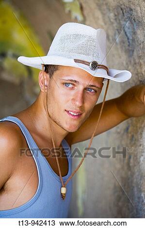 Stock Image - Young man portrait with White hat. Fotosearch