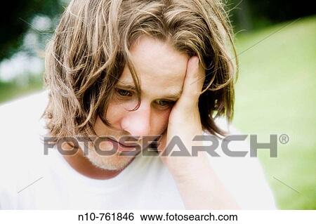 Young man posing on the grass at a park View Large Photo Image Stock Photograph - Young man posing on the grass at a park. Fotosearch