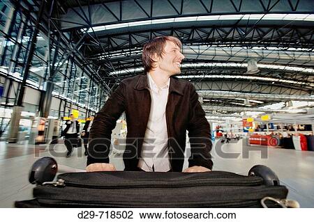 Young man pushing cart at airport View Large Photo Image Stock Image - Young man pushing cart at airport. Fotosearch