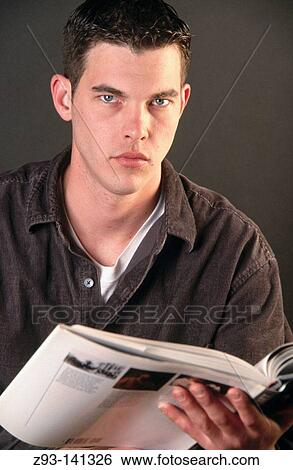 Stock Photograph - Young man reading book. Fotosearch