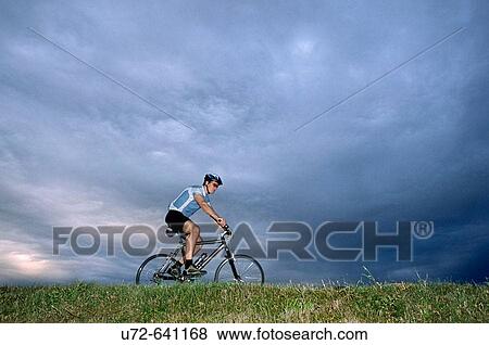 Stock Photo - Young man riding a mountain bike. Fotosearch