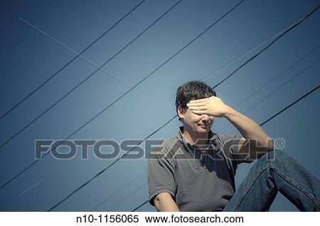 Young man sitting beneath power lines View Large Photo Image Stock Photography - Young man sitting beneath power lines. Fotosearch