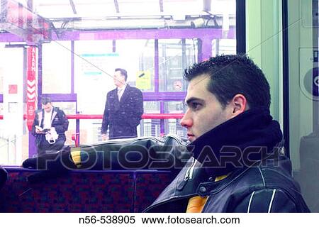 Young man sitting on a train. View Large Photo Image Stock Photography - Young man sitting on a train.. Fotosearch