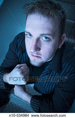 Young man, sitting on his stairs, making a fist View Large Photo Image Picture - Young man, sitting on his stairs, making a fist. Fotosearch