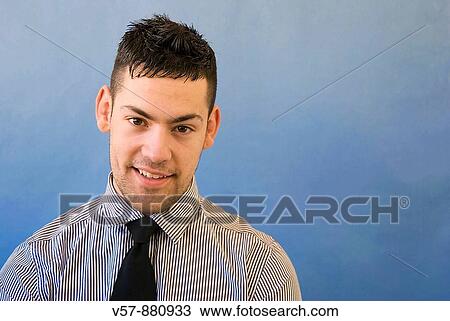 Stock Image - Young man smiling and looking at the camera. Fotosearch