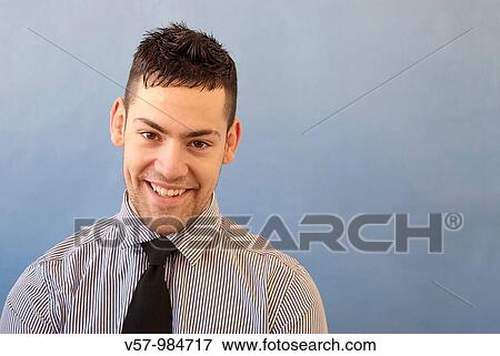 Young man smiling and looking at the camera View Large Photo Image Stock Photo - Young man smiling and looking at the camera. Fotosearch