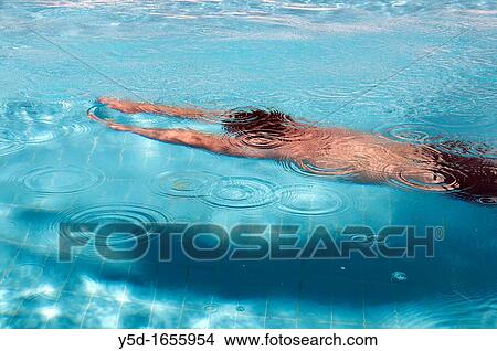 young man swimming under water in the swimming pool in companionship of his shadow View Large Photo Image Picture - young man swimming under water in the swimming pool in companionship of his shadow. Fotosearch
